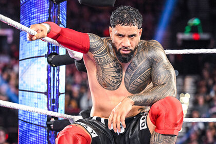 Jey Uso kneels against the ropes