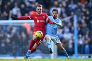 Alexis Mac Allister of Liverpool and Bernardo Silva of Manchester City battle for the ball during a game.