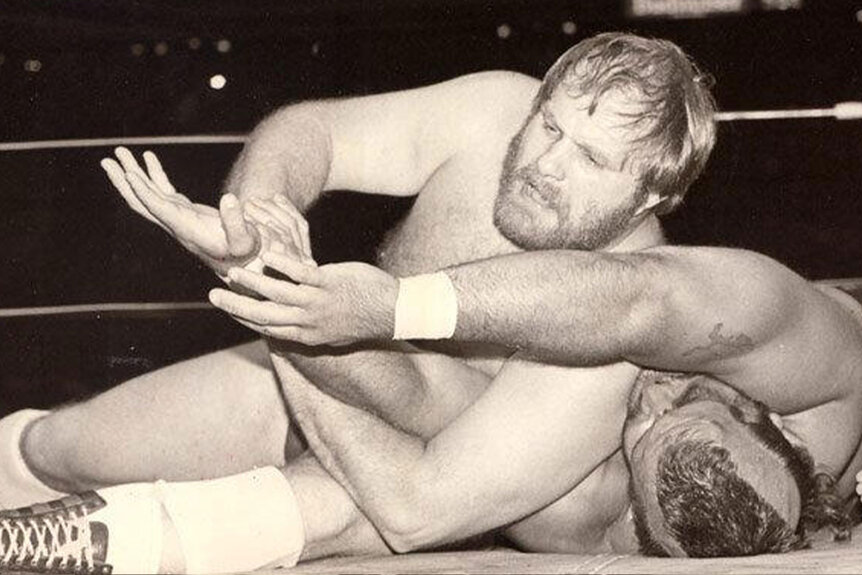 Ole Anderson wrestling an opponent on the mat of the ring