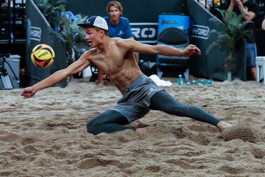 Miles Partain dives to hit a volleyball.