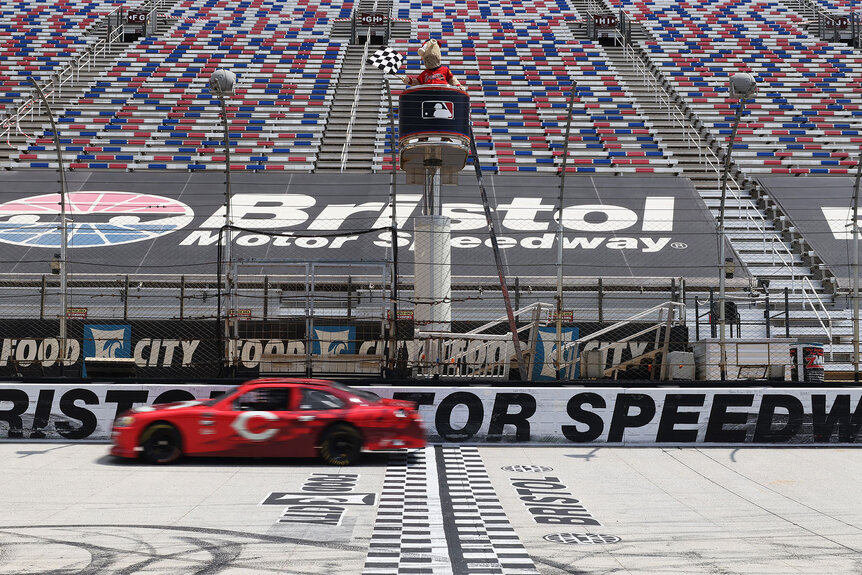 The Cincinnati Reds race car drives laps in front of an empty arena during the MLB Speedway Classic at Bristol Announcement