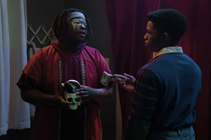 Cliff (Elijah Richardson) hands a dollar to a costumed Spud (Kezii Curtis) on Hysteria! Episode 103