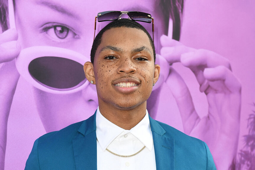 Elijah Richardson wears a blue suit and smiles on the red carpet for Hollywood Stargirl