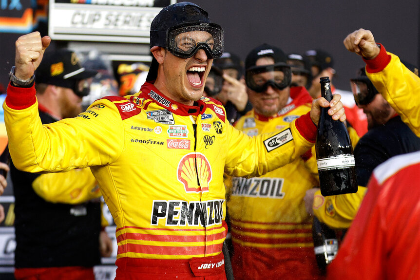 Joey Logan and crew spray champagne in victory lane