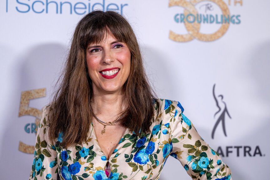 Edi Patterson smiles in a blue floral shirt.