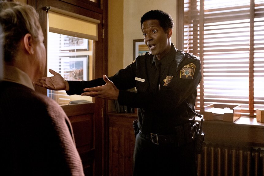 Sheriff Mike Thompson (Corey Reynolds) speaks and points his arms on Resident Alien Episode 402.